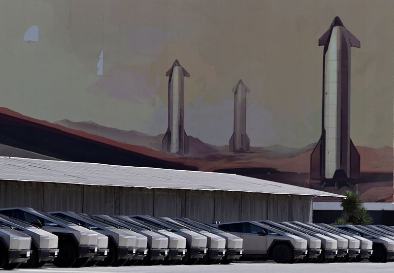 Tesla Cyber trucks parked at charging stations outside the SpaceX launch production facility in Starbase