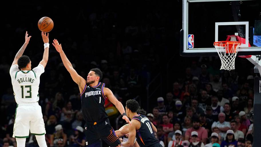 Suns guard Devin Booker (1) defends Bucks guard Ryan Rollins (13)