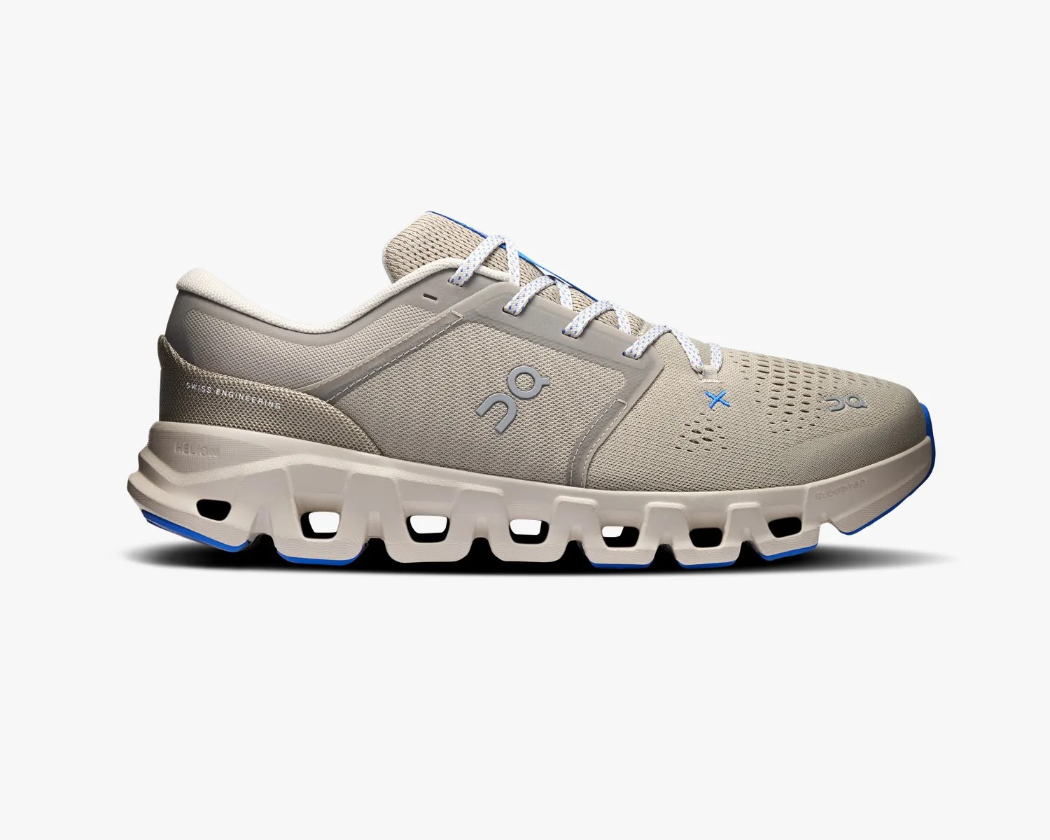 Light beige athletic shoe with white laces, blue accents, and a uniquely segmented sole.