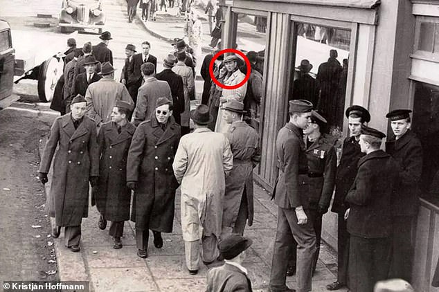 A photograph, captured on a busy street in Reykjavik, Iceland, in 1943 during World War II, appears to show a smartly dressed man among a crowd of soldiers holding an object to his ear