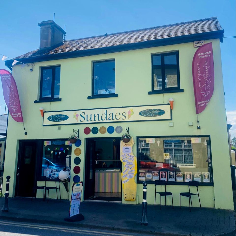 A storefront named Sundaes with outdoor seating and decorated banners