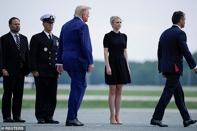 Trump walks by his Executive assistant Natalie Harp as they attend a dignified transfer
