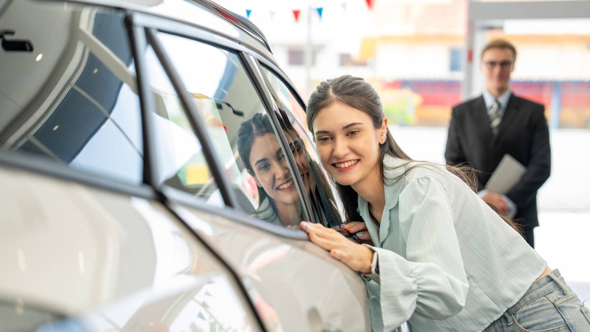 woman-smiling-while-exploring-new-car-in-dealership
