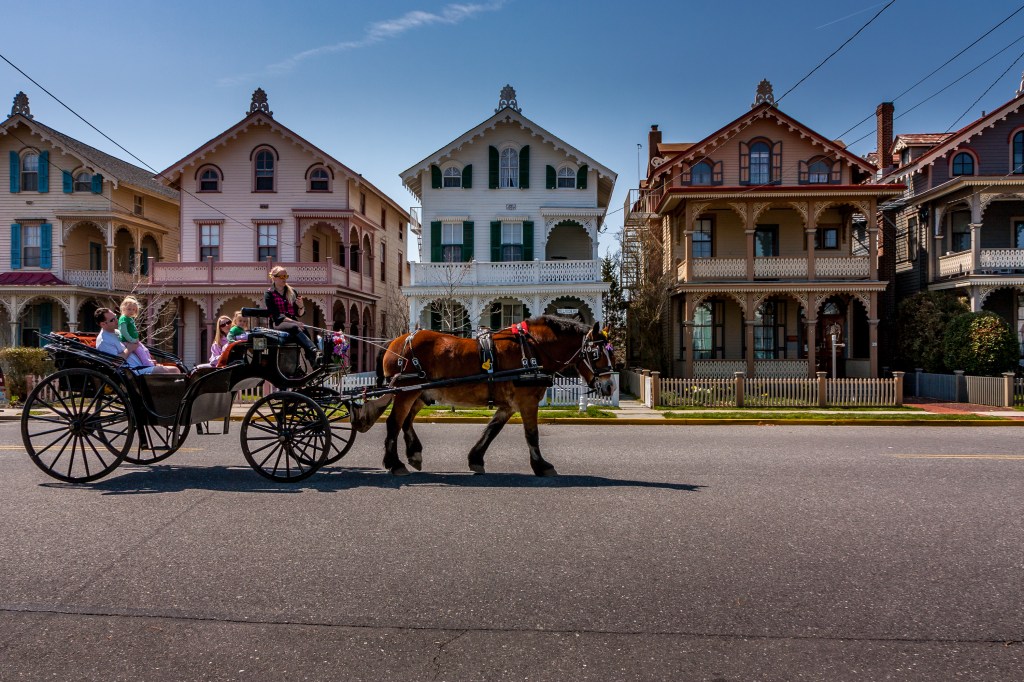 A carriage carries tourists past a row of Victorian