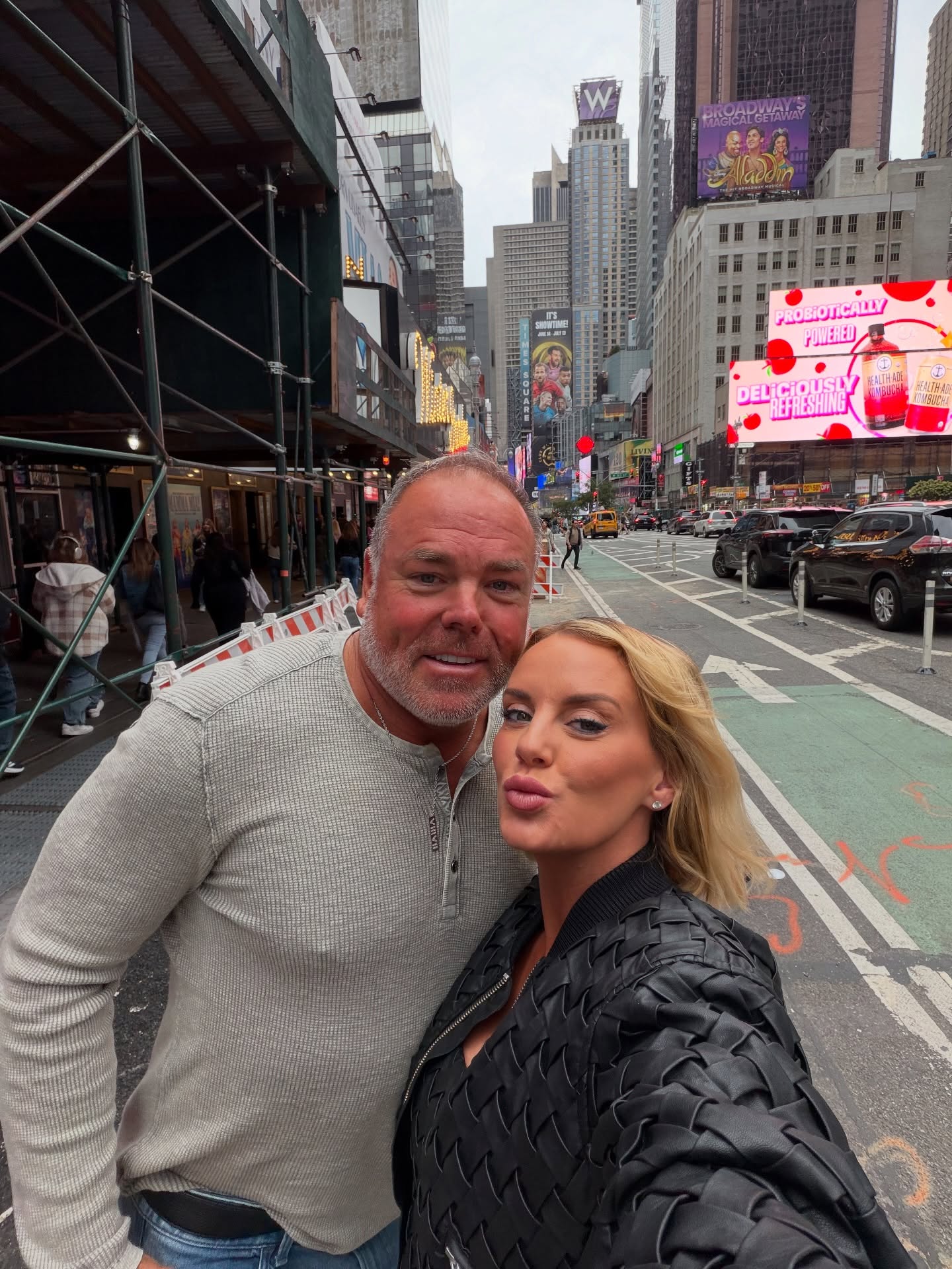 Whitney and Justin Rose take a selfie on a city street.