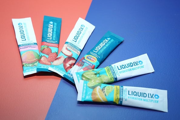 Packets of Liquid I.V. hydration powder in various flavors are arranged in a fan shape