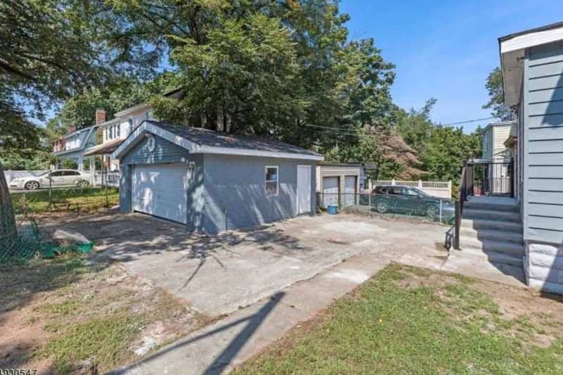 Empty concrete area between garage and house before renovation.