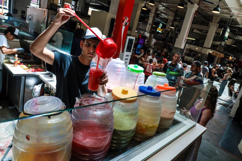 Brian Hernandez fills a juice order at La Fruteria at Grand Central Market in Los Angeles.
