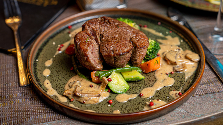 A plate of steak marsala with veggies