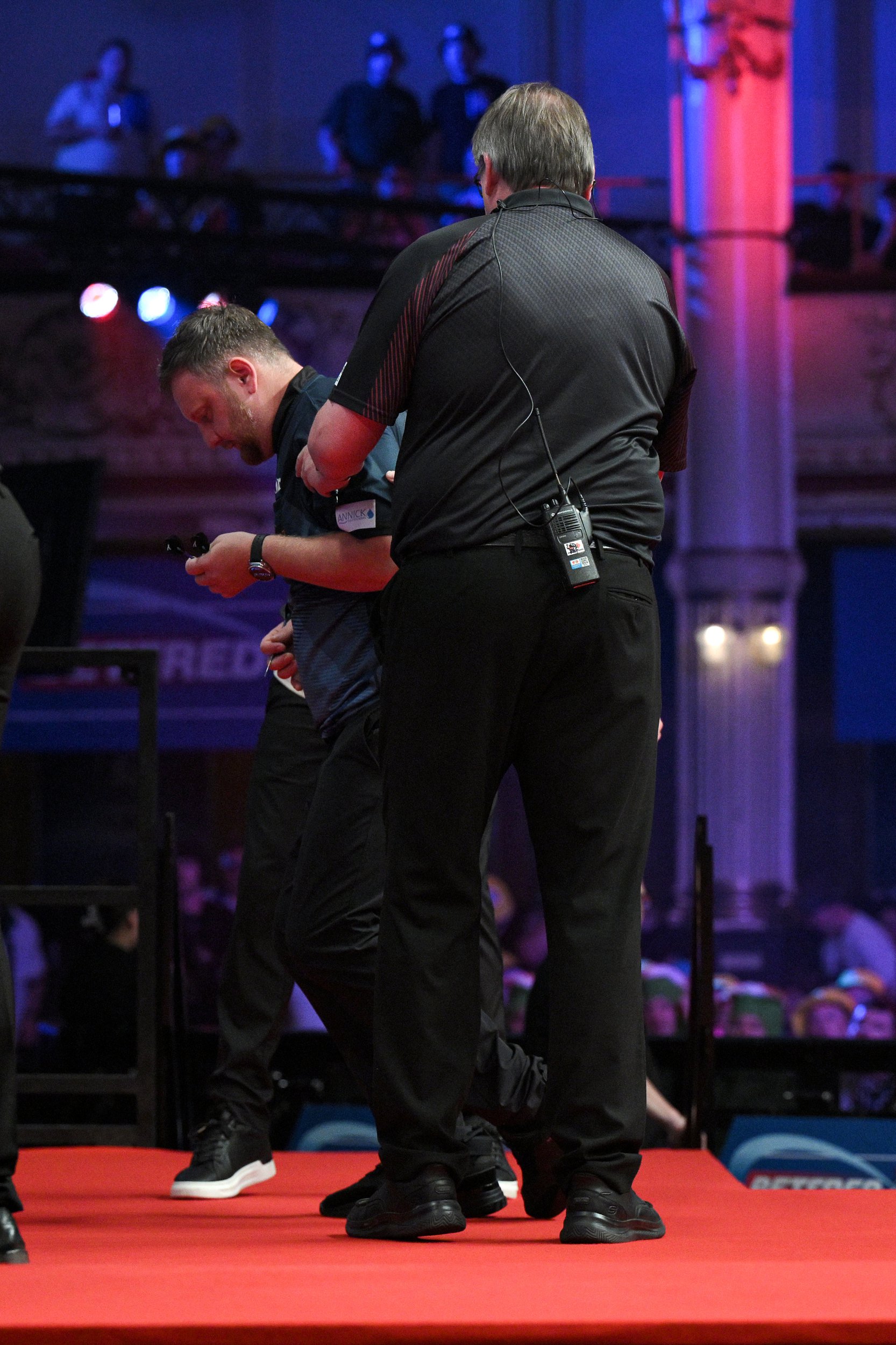BLACKPOOL, ENGLAND - JULY 22: Cameron Menzies is helped from the stage after being taken ill during the match during day five of the 2026 Betfred World Matchplay at Winter Gardens on July 22, 2026 in Blackpool, England. (Photo by Ben Roberts Photo/Getty Images)