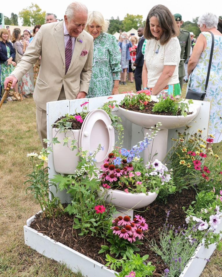 King Charles III and Queen Camilla smile as they view discarded materials that have been repurposed to create mini containers during the first RHS Sandringham Flower Show at Royal Sandringham Estate on July 22, 2026 in Sandringham, Norfolk