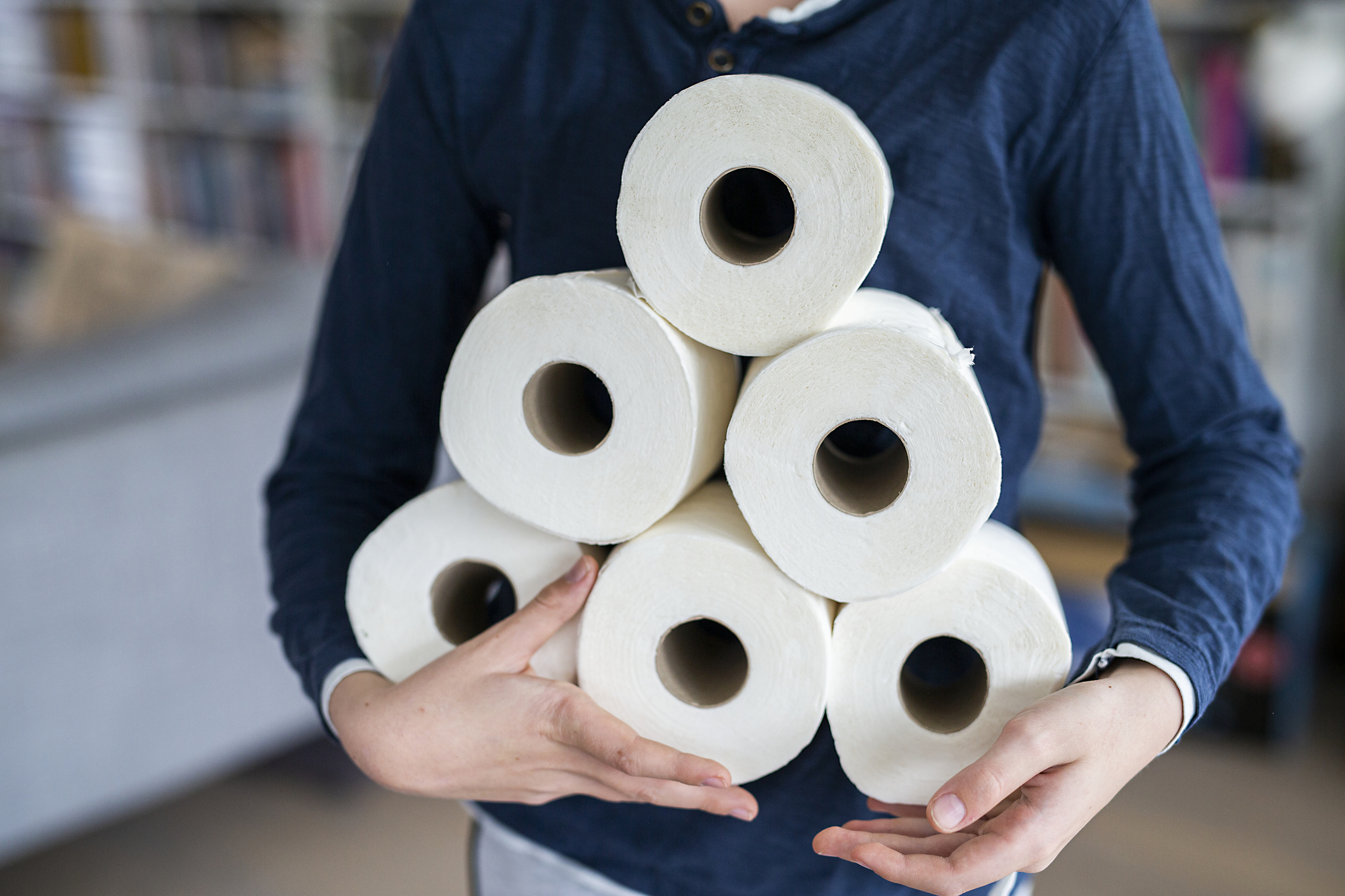 a person holding toilet paper rolls