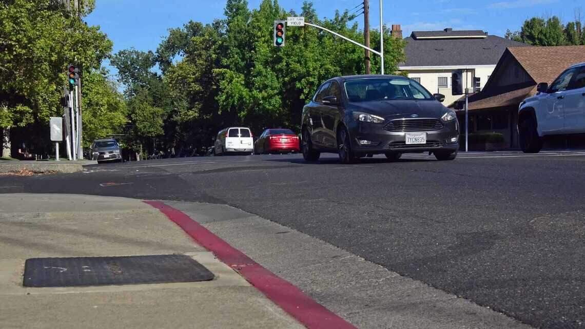 A painted red curb marks a no parking zone near the intersection of 39th and J streets in East Sacramento on Tuesday, July 21, 2026. Sacramento is painting some curbs to help drivers identify parking restrictions under California's daylighting law, even though the markings are not required and the city says funding limits how quickly affected intersections can be marked.