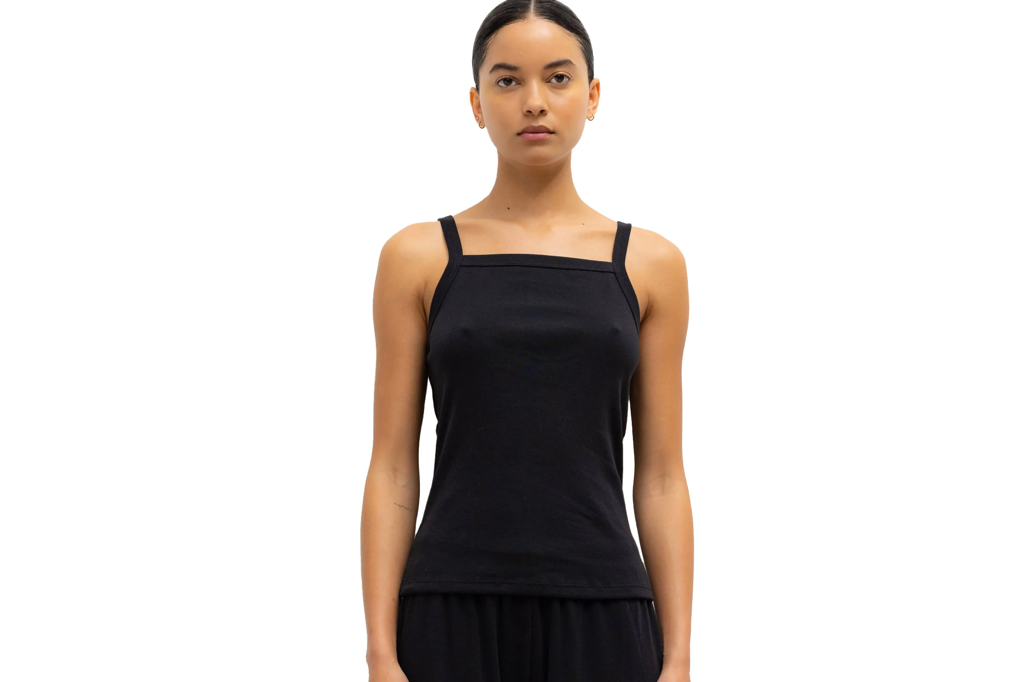 A woman wearing a black tank top and black pants.