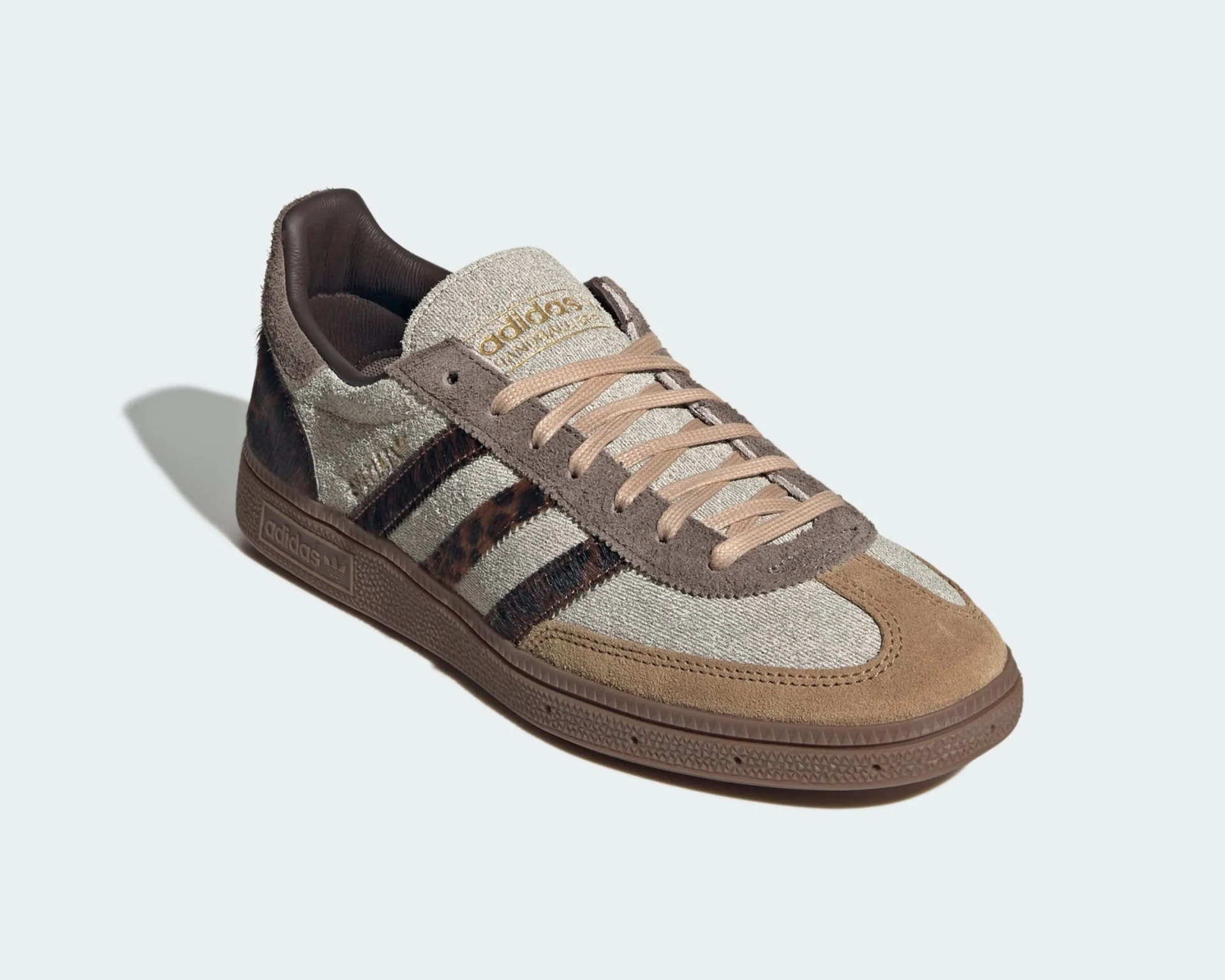 Beige and brown Adidas sneaker with leopard print stripes and gum sole on a light background.