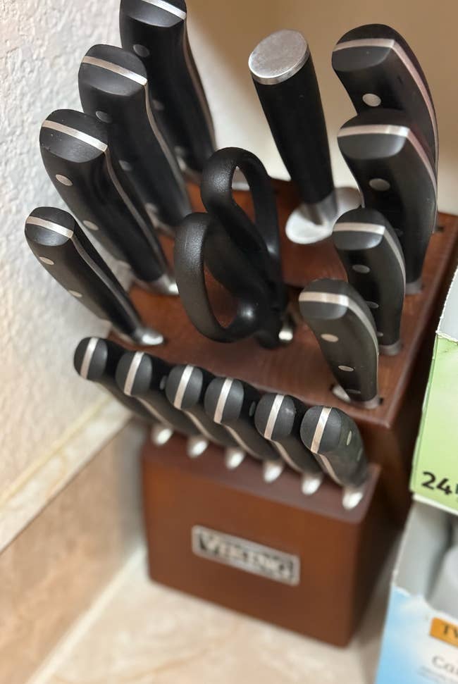 Knife block set with various kitchen knives and scissors, placed on a countertop