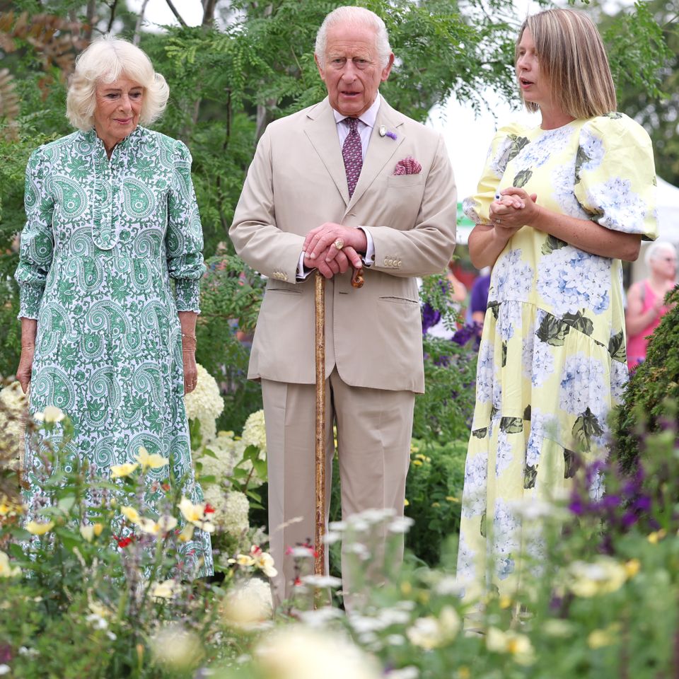 Queen Camilla and King Charles III speak with garden designer Catherine MacDonald as they visit the Royal Legacy Garden at the first RHS Sandringham Flower Show at Royal Sandringham Estate on July 22, 2026 in Sandringham, Norfolk