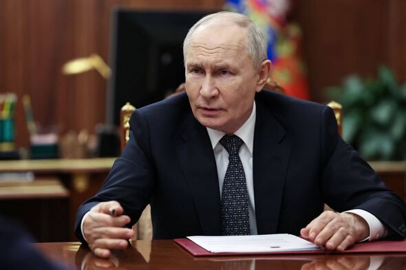 Vladimir Putin sitting at a desk
