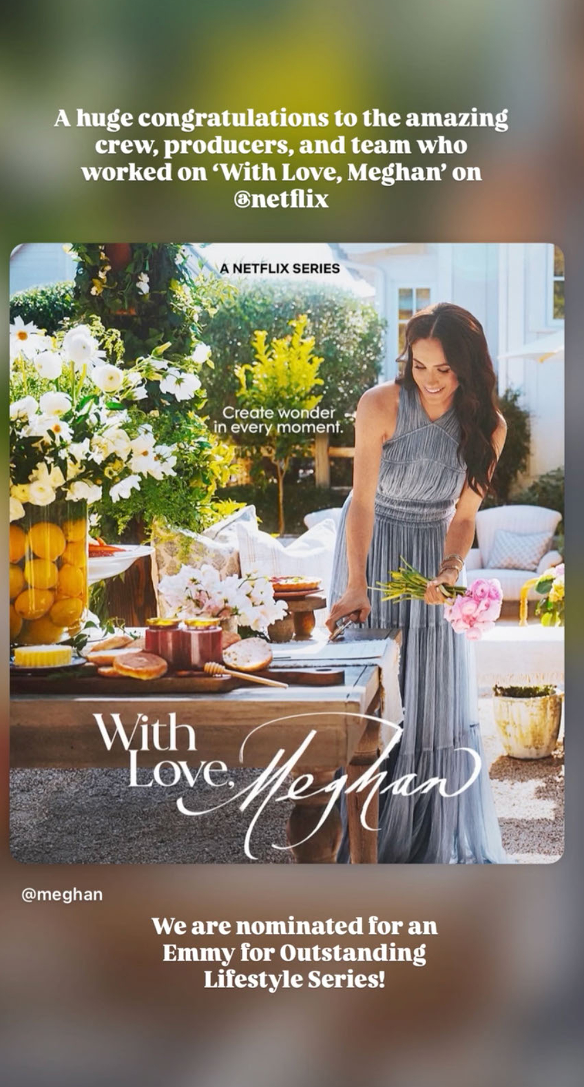 Meghan Markle in a light blue dress standing next to a table with flowers, honey, and pastries on a patio.