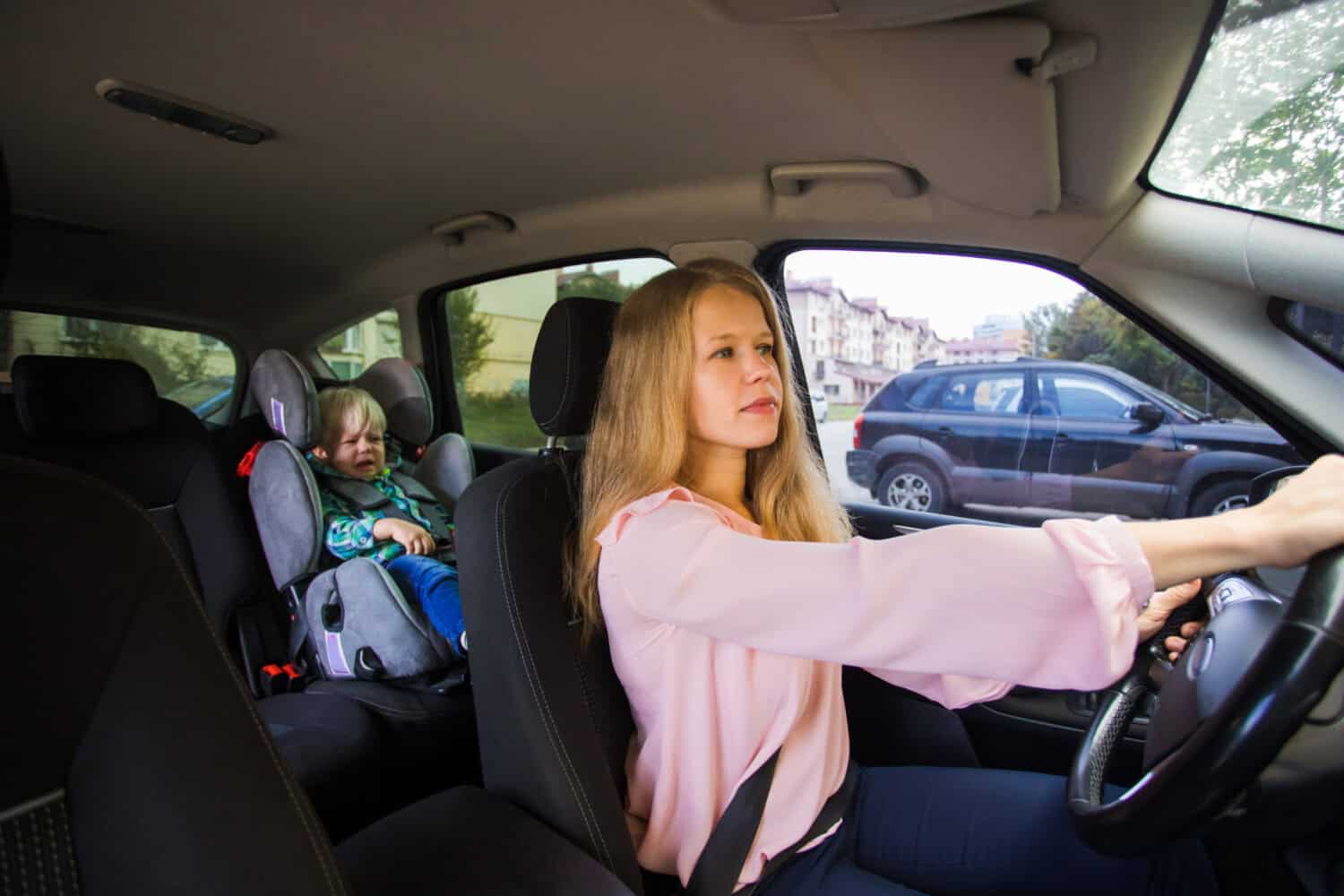 Female nanny drive the car and deliver toddler boy