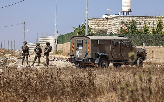 Members of Israeli security forces stand guard at the demolition site of a Palestinian agricultural facility that was reportedly built without a permit in the village of Rafat, south of Ramallah, in the West Bank on July 22, 2026. (Zain JAAFAR/AFP)