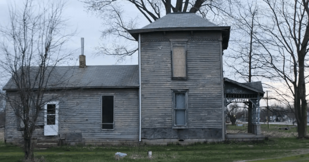 Exterior side view of the spooky, weathered old farmhouse at Revenant Acres Farm in Indiana.