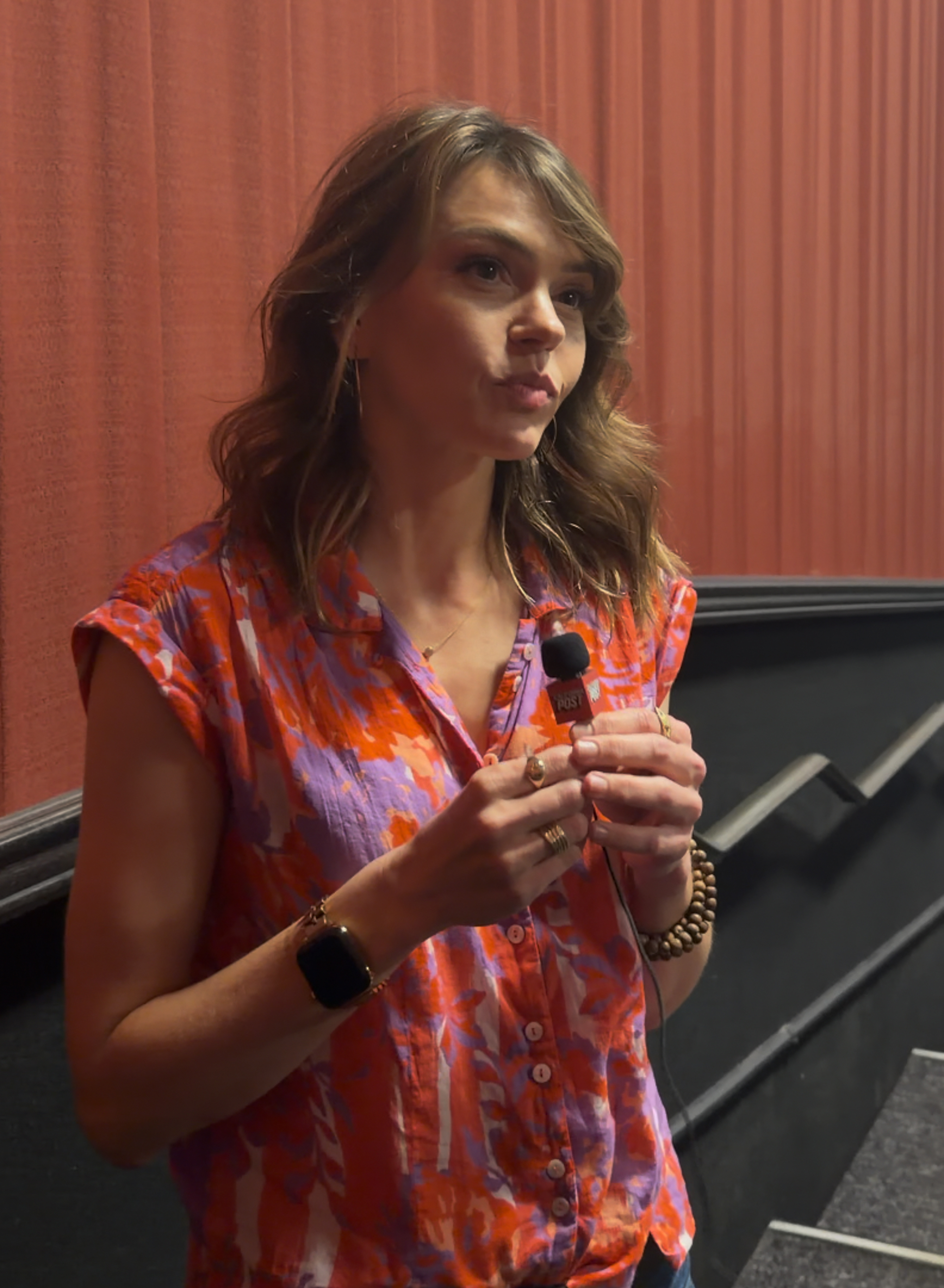 Actress Aimee Teegarden holds a microphone from 