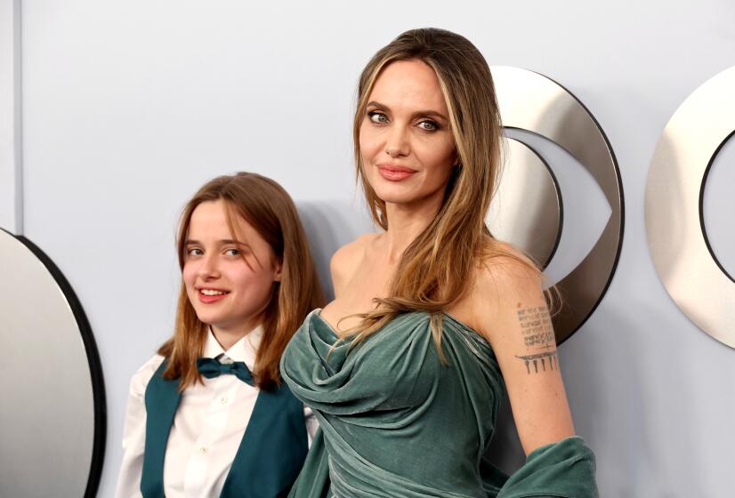 Vivienne Jolie-Pitt and Angelina Jolie, wearing coordinated mint outfits, pose for cameras.