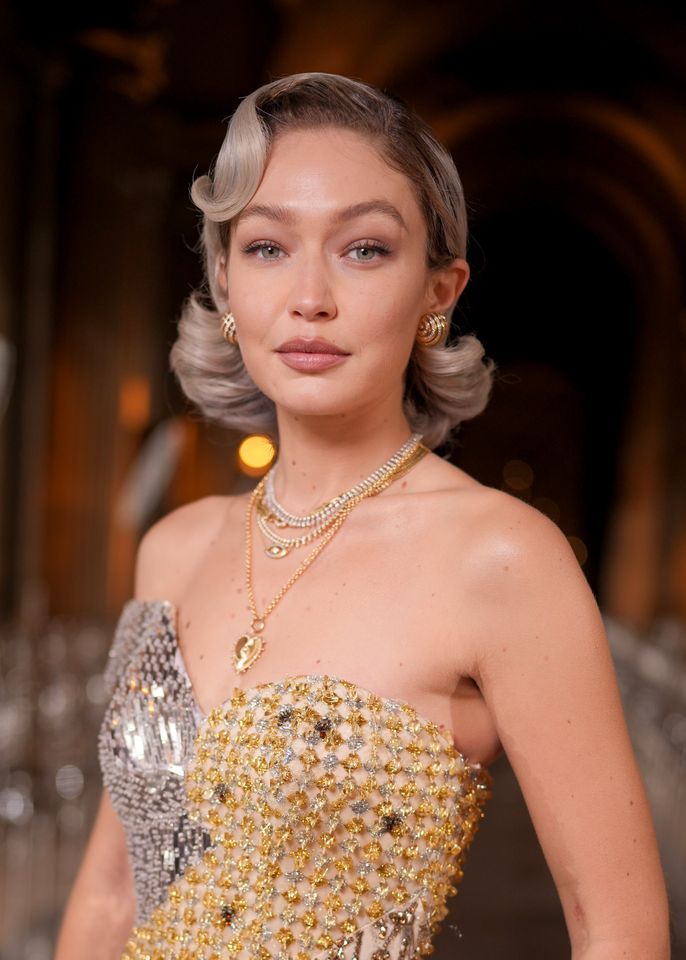 Gigi Hadid at an event wearing a stylish gown and jewelry
