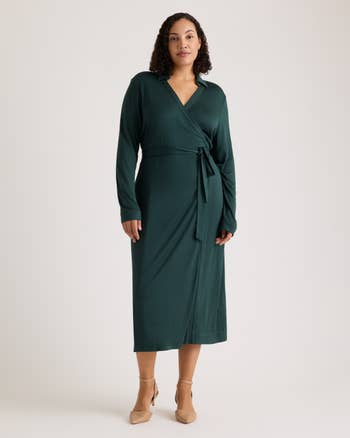 A person wearing a wrap-style midi dress, paired with heels