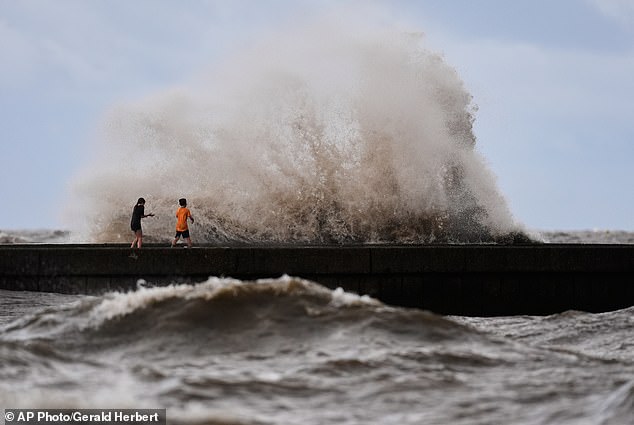 Bertha made landfall in the afternoon in St Bernard Parish, Louisiana, about 40 miles east of New Orleans. Children are pictured playing near breaking waves on the Louisiana coast ahead of the storm