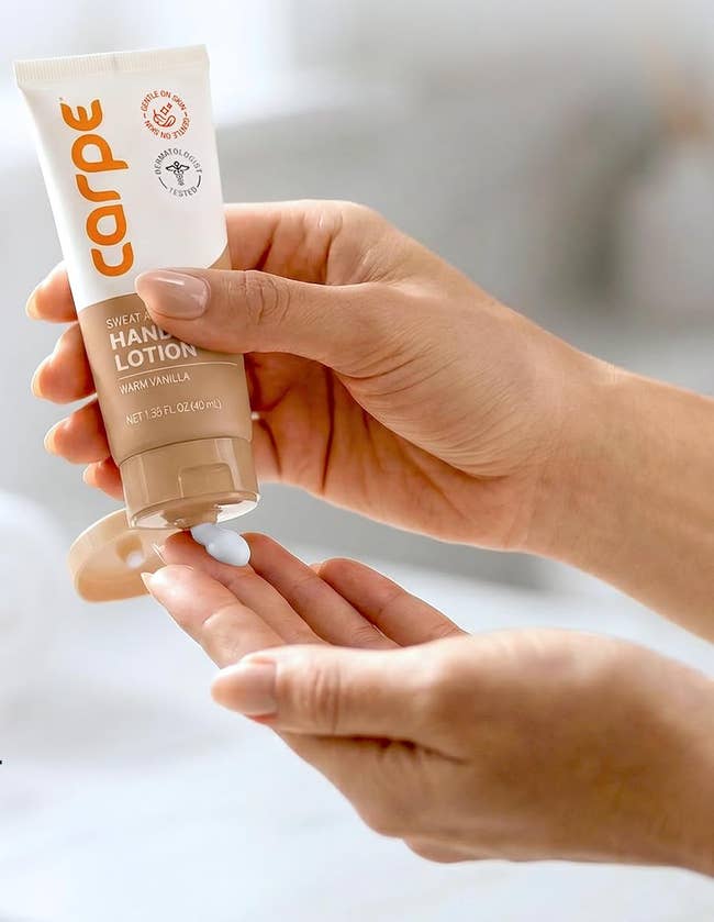 Hands applying a small amount of Carpe sweat-absorbing hand lotion, labeled