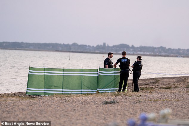 Police officers at West Mersea beach last night. The beach remains closed this morning