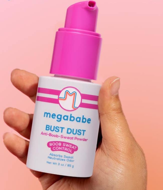 Hand holding a bottle of Megababe Bust Dust, an anti-boob-sweat powder, in a shopping context