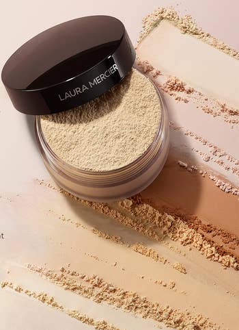 Open jar of Laura Mercier translucent powder with scattered powder background and testimonials claiming it controls shine, lasts long, and feels lightweight