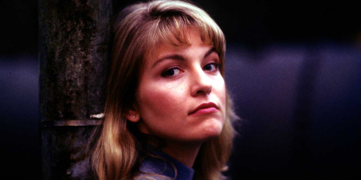 Laura Palmer stands against a tree in Twin Peaks