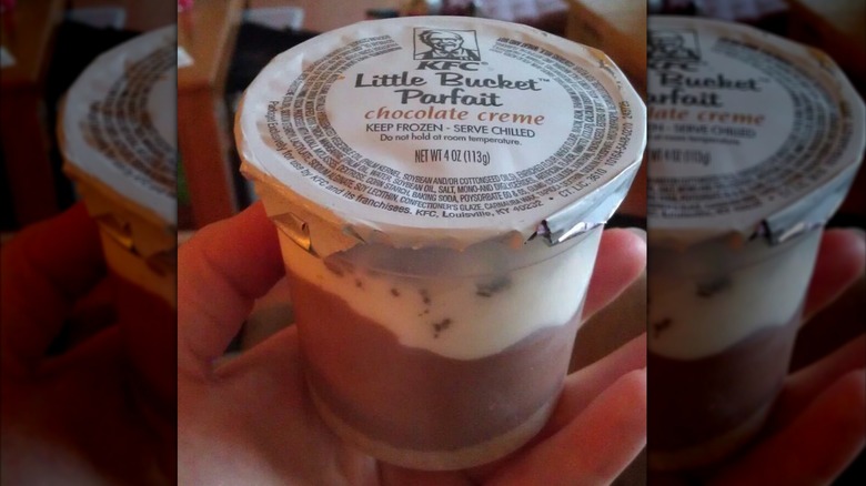 Hand holding unopened chocolate creme KFC Little Bucket parfait