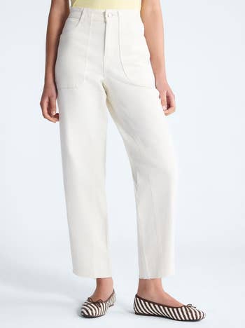 Person in high-waisted, wide-leg white jeans paired with striped flats