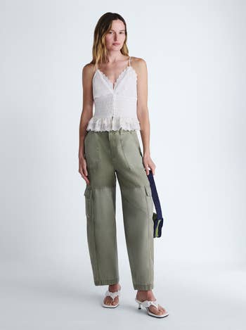 Person wearing a sleeveless lace top with loose cargo pants and sandals