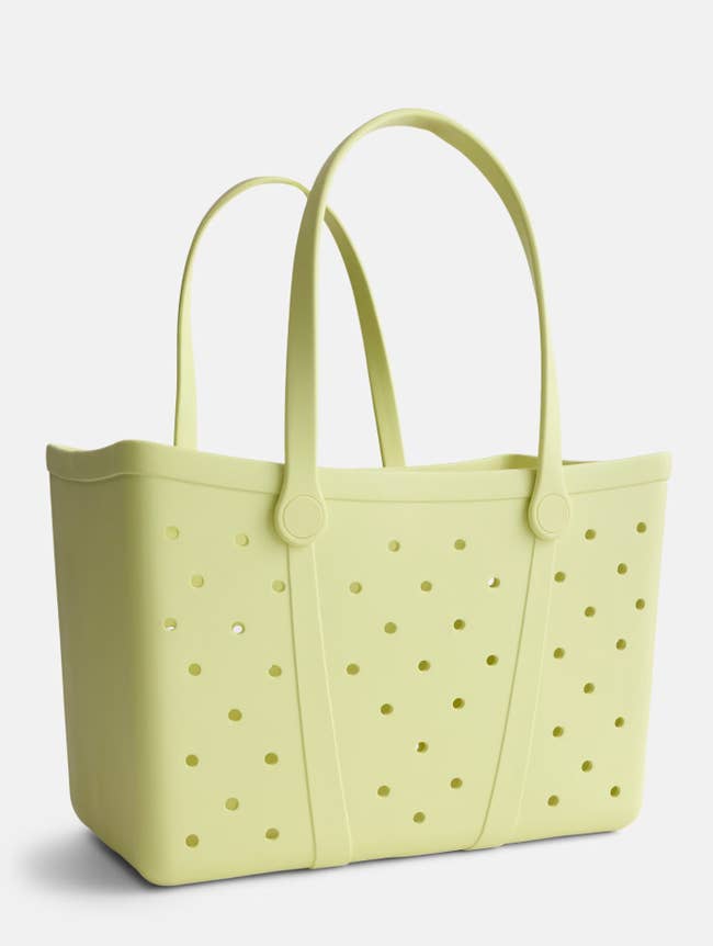 Perforated tote bag with long handles, ideal for beach or shopping use