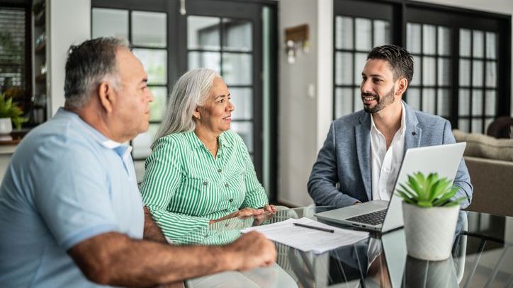 A financial advisor having a meeting with senior couple at home.