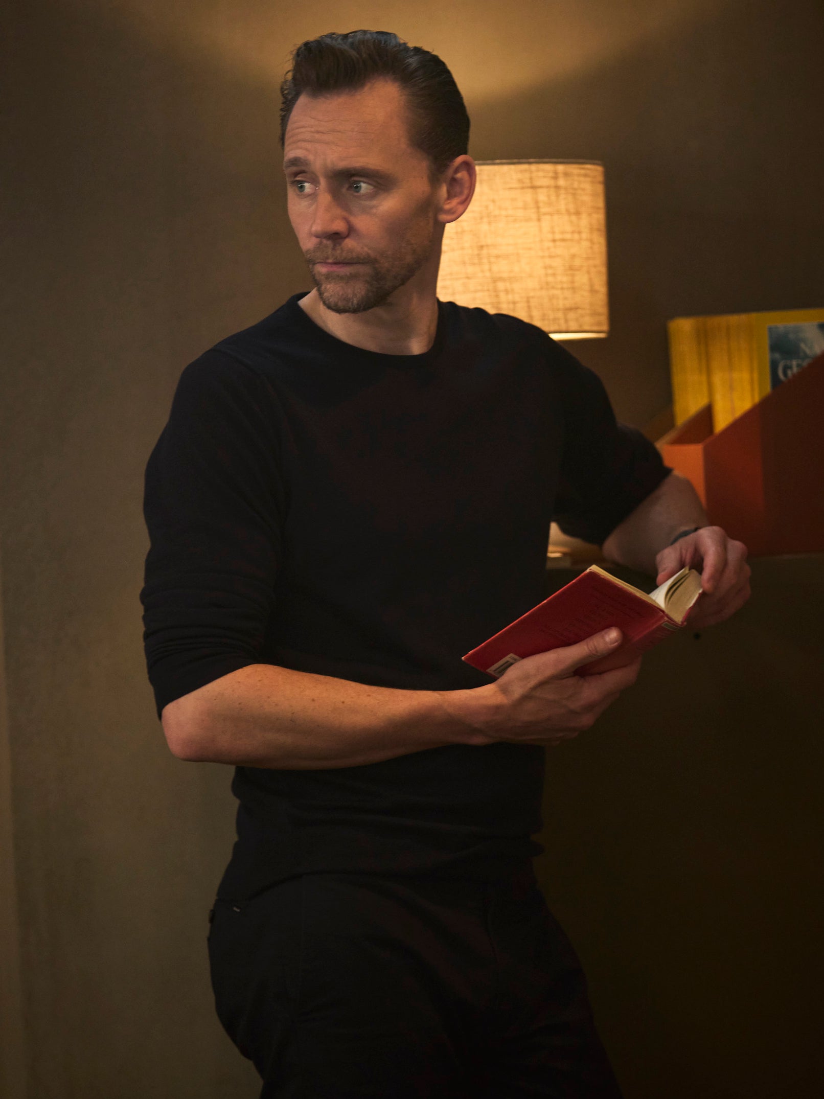 Tom Hiddleston looks up from an old book (National Geographic/Christian Black)