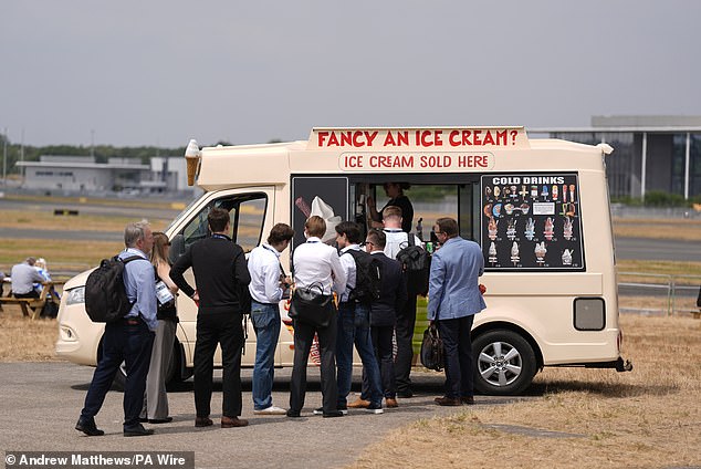 People queue for ice cream at the Farnborough International Airshow in Hampshire yesterday