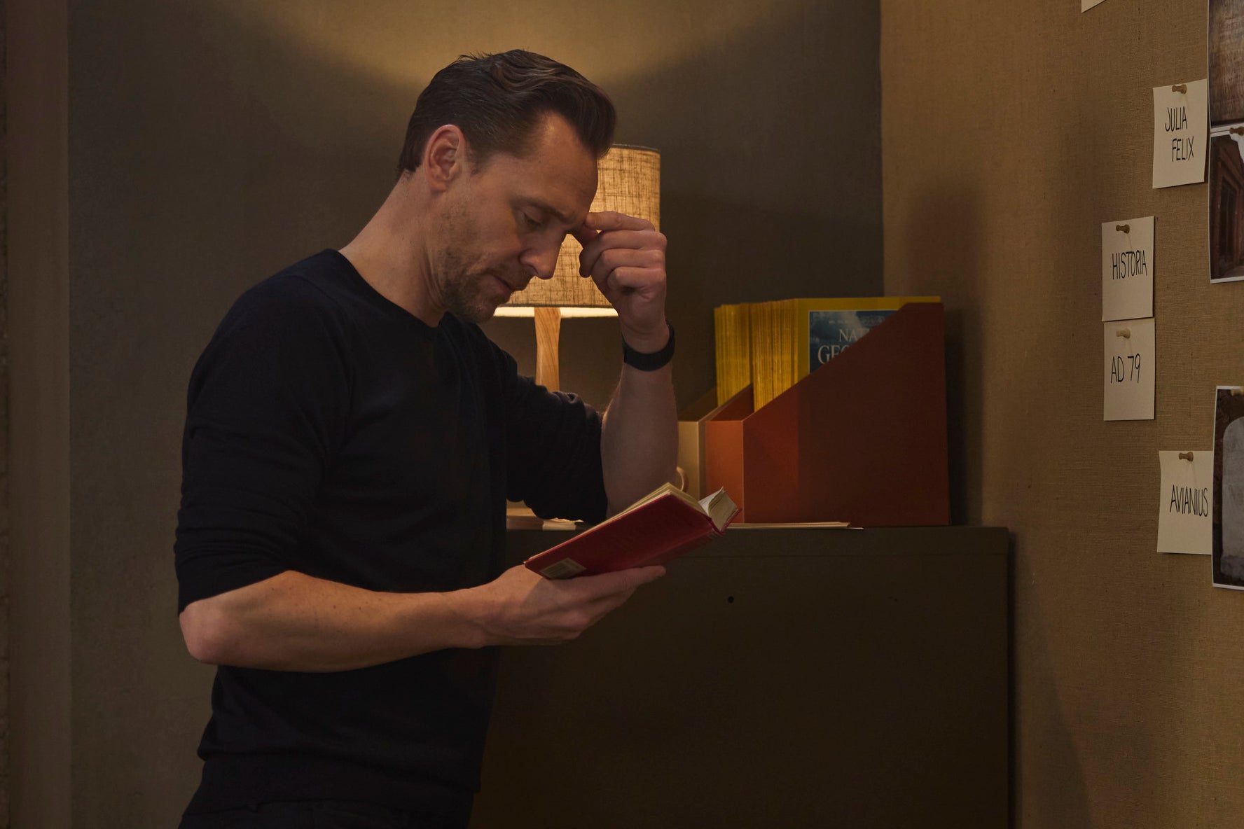 Tom Hiddleston looks at an old book (National Geographic/Christian Black)