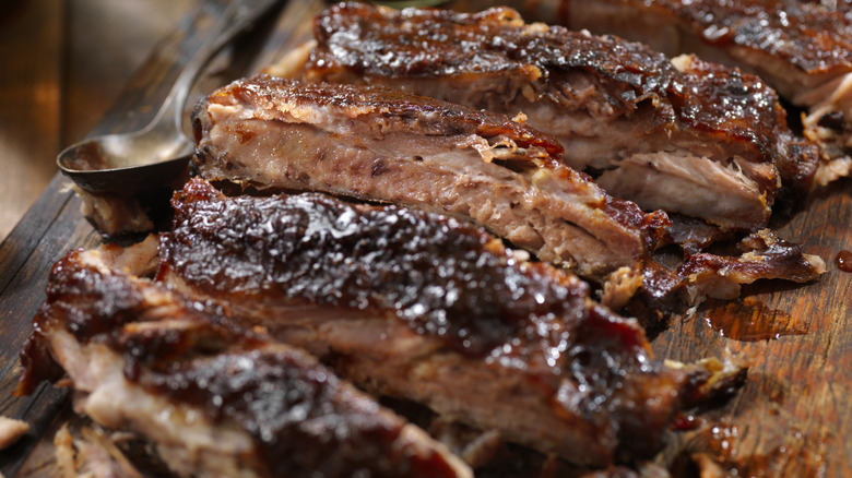 BBQ ribs on a cutting board with a spoon