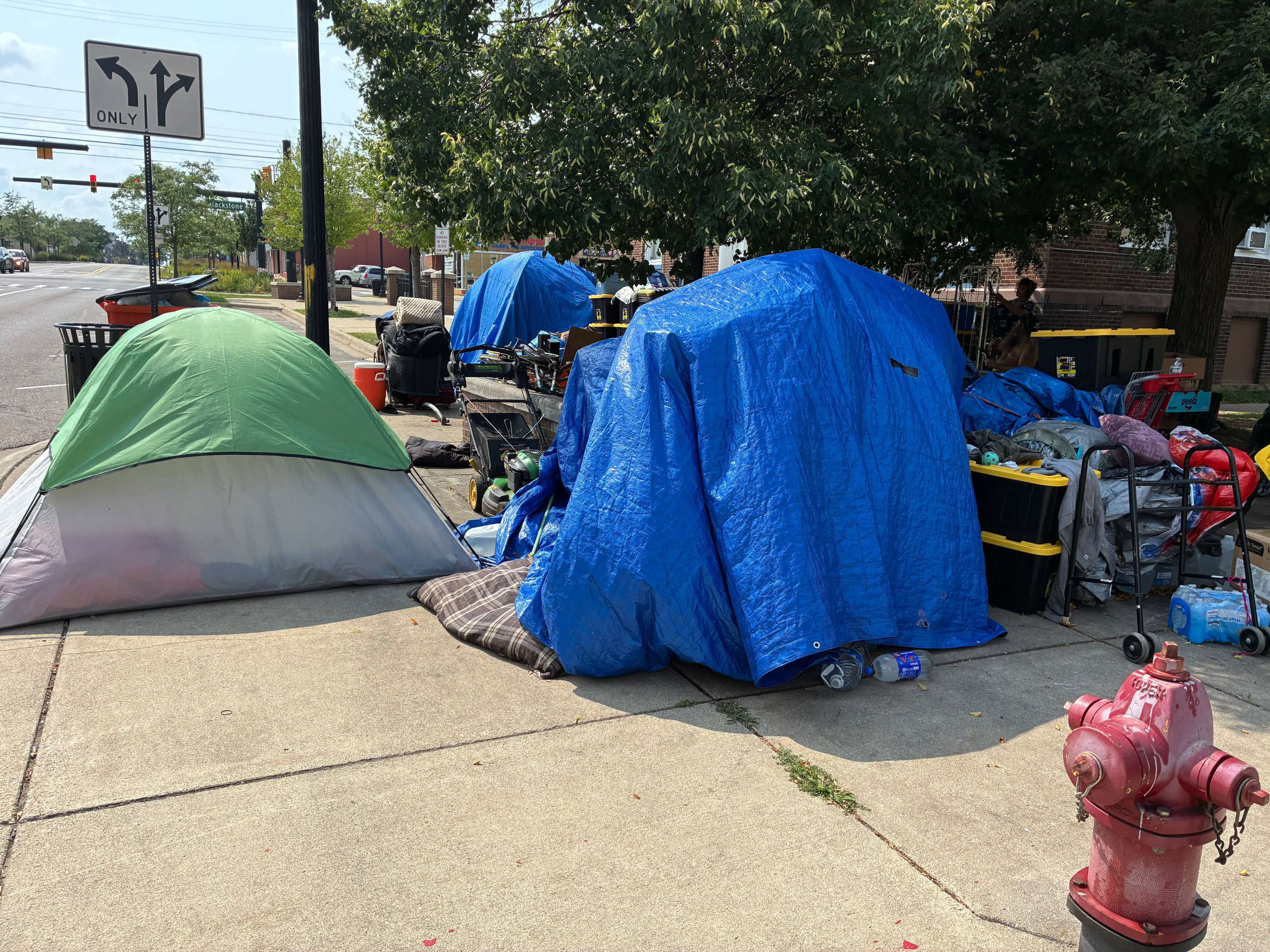 Tents and other possessions sit on the sidewalk outside the downtown Jackson library on W. Michigan Avenue.