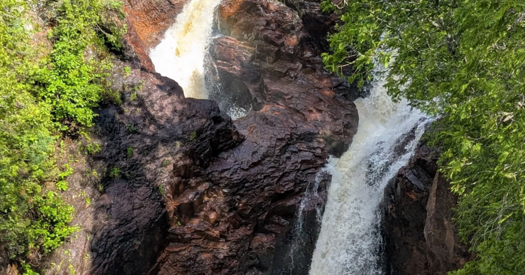 Close-up of the mysterious Devil's Kettle waterfall plunging into a deep, dark rock pothole in Minnesota.