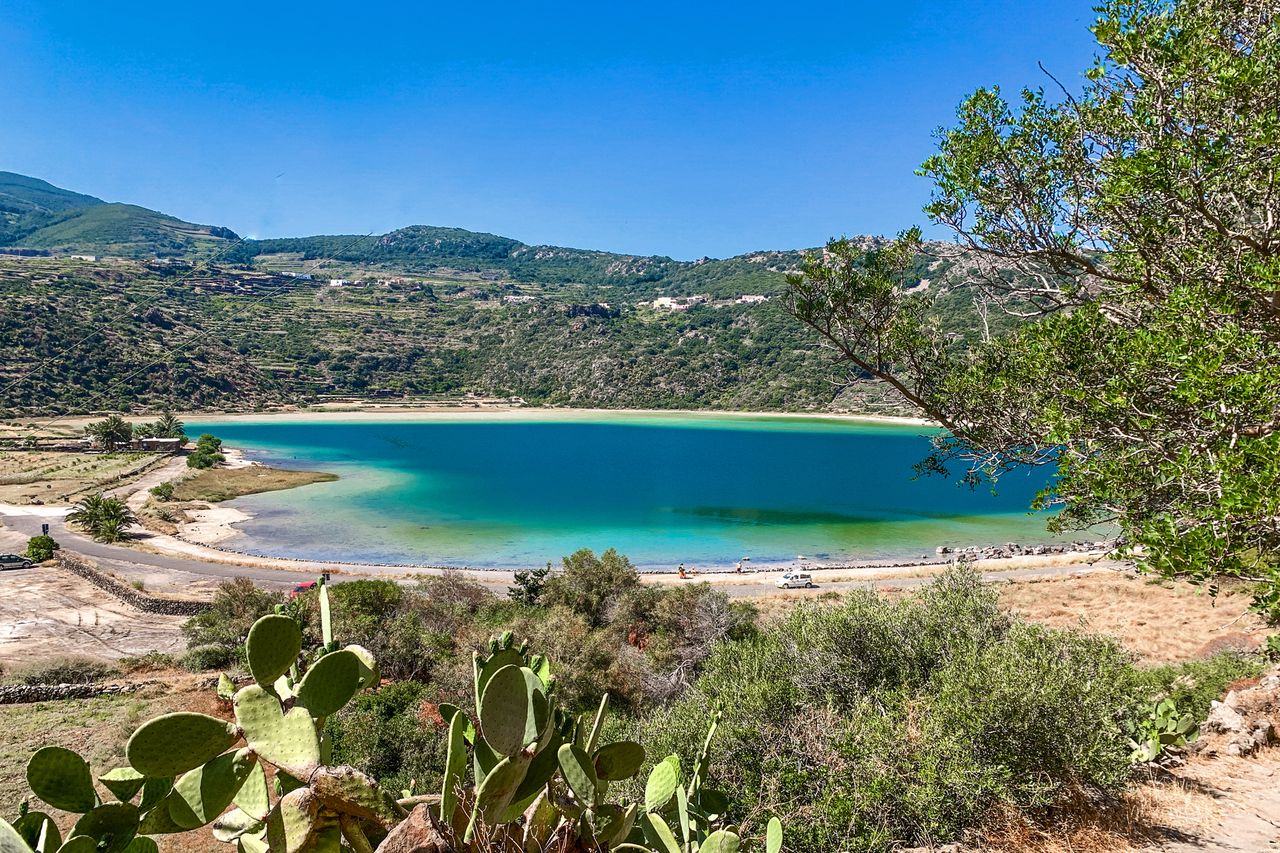 Scenic lake surrounded by greenery and hills view from a high vantage point