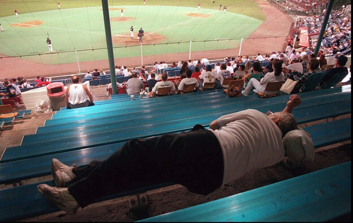 A Wichita baseball fan takes a nap during the Baseball ‘Round The Clock promotion at the 1997 NBC World Series. After an eight-year hiatus, the promotion is returning this summer.