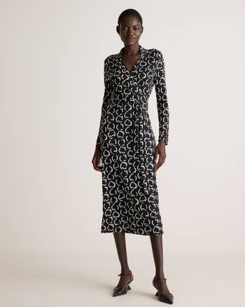 Model in knee-length, long-sleeve wrap dress with a geometric pattern, standing confidently